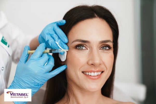 Photo of smiling woman getting mesotherapy treatment in face